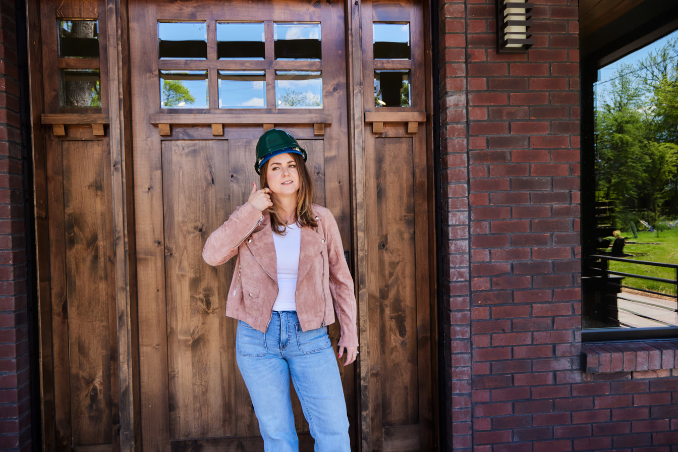 Erin Tunney wearing a hard hat at the entrance of a Nashville home